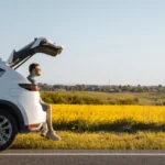 man sitting in car trunk enjoying view of sunset